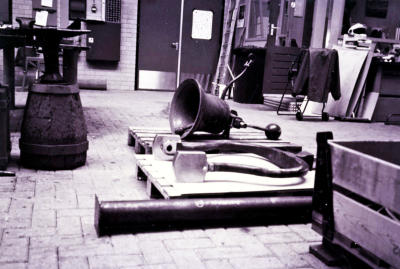 De gerestaureerde bel en ophangbeugel in de smederij van de Rijkswerf Willemsoord, 1993.   Bron: HisDocMB